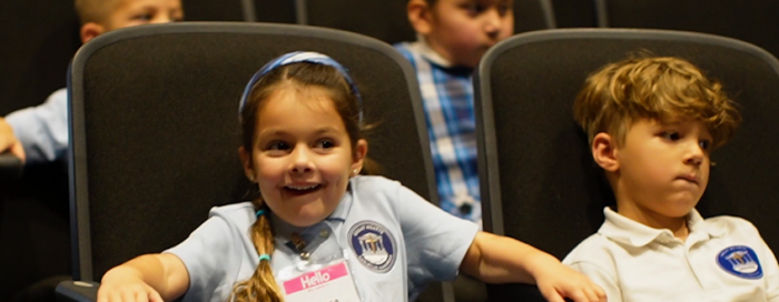 Two students sitting in auditorium seats